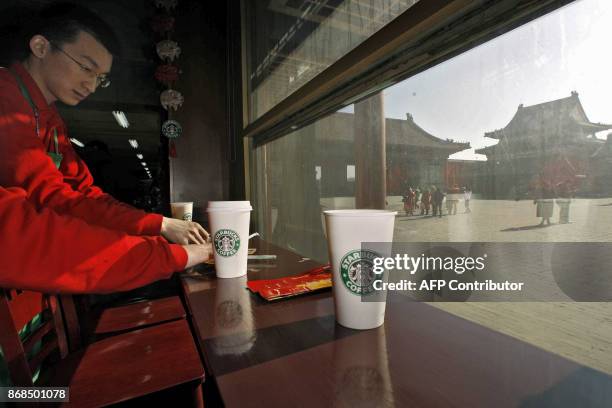 Waiter cleans up at the Starbucks coffee shop in Beijing's Forbidden City 18 January 2007. An online campaign to exile the US coffee giant from the...