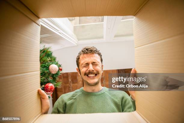 hombre abriendo regalo de navidad - gift suprise funny fotografías e imágenes de stock