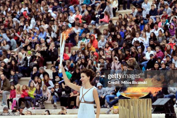 Actress Katerina Lechou, playing a high priestess, holds the lit torch at The Panathenaic Stadium during the handover ceremony of the Olympic flame...