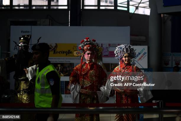 Malaysian policeman keeps a watch as opera artists from the Teochew Puppet and Opera House perform at the Masjid Jamek station in Kuala Lumpur on...