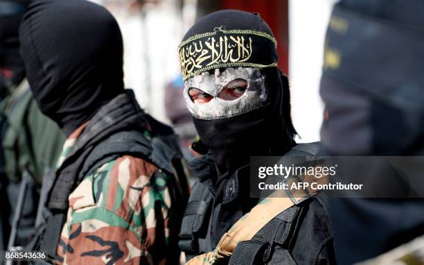 Members of the Palestinian Islamic Jihad Movement and masked militants attend the funeral of comrades killed in an Israeli operation to blow up a...