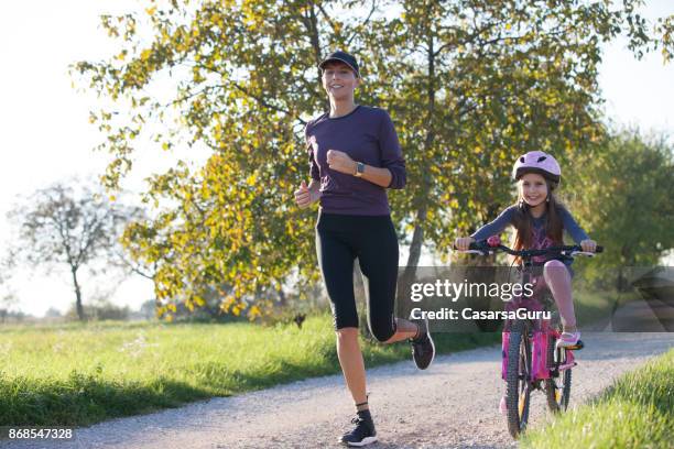 mutter und tochter, die sportliche aktivität im freien genießen - bicycle daughter stock-fotos und bilder