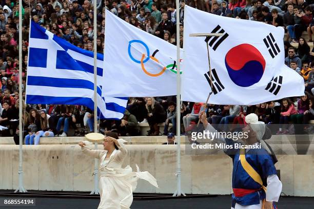 Korean dancers dressed in traditional costume perform infront of the Greek, Olympic and South Korean flags during a handover ceremony for the Olympic...