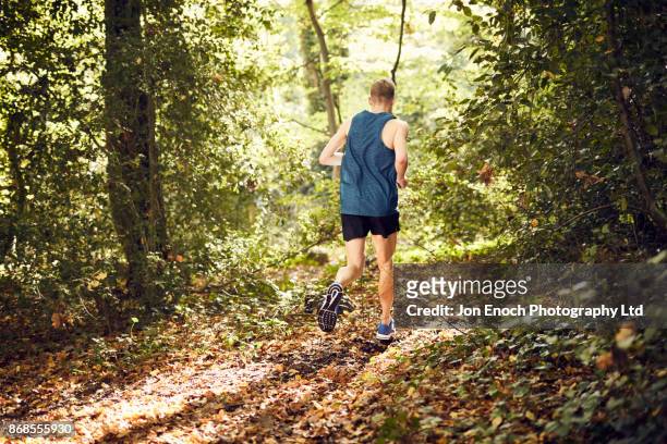 man running in woods - jon enoch stock pictures, royalty-free photos & images