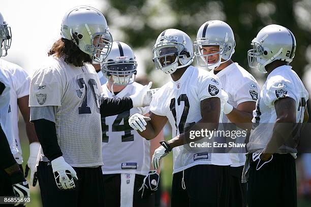 Darrius Heyward-Bey of the Oakland Raiders jokes with Robert Gallery in the huddle during the Raiders minicamp at the team's permanent training...