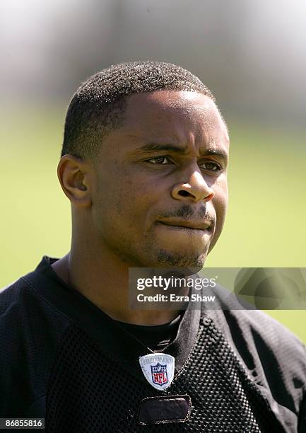 Nnamdi Asomugha of the Oakland Raiders watches practice from the sideline during the Raiders minicamp at the team's permanent training facility on...