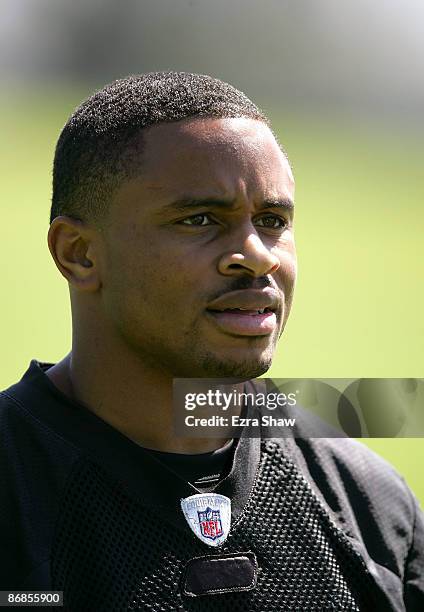 Nnamdi Asomugha of the Oakland Raiders watches practice from the sideline during the Raiders minicamp at the team's permanent training facility on...