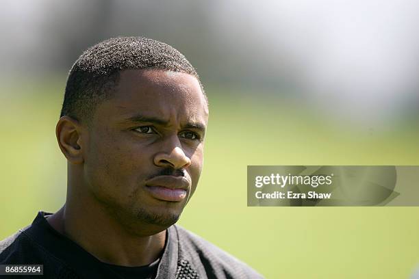 Nnamdi Asomugha of the Oakland Raiders watches practice from the sideline during the Raiders minicamp at the team's permanent training facility on...