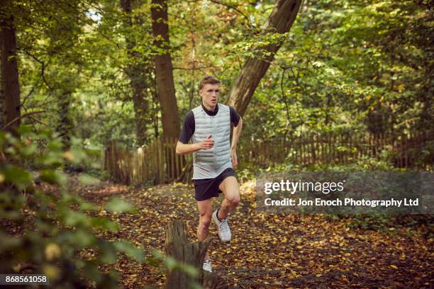 man running in woods - jon enoch stock pictures, royalty-free photos & images