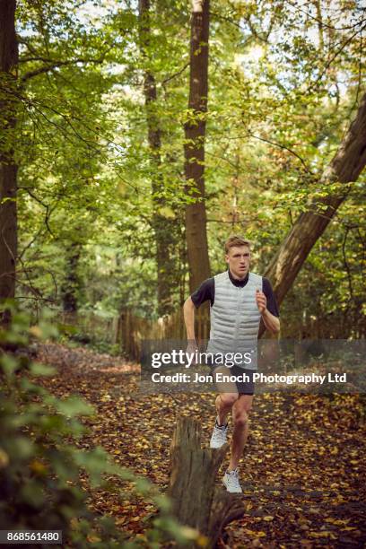 man running in woods - jon enoch stock pictures, royalty-free photos & images