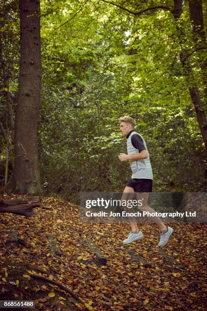 man running in woods - jon enoch stock-fotos und bilder