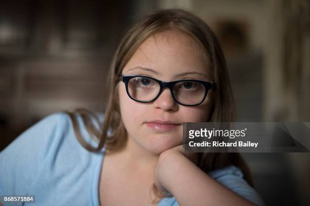 Teenage girl with Down syndrome looking into camera.