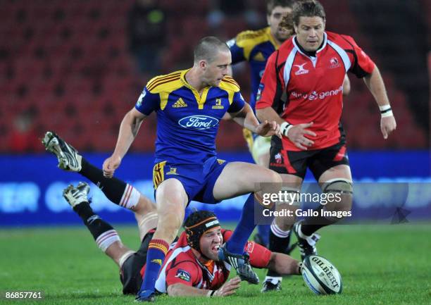 Ben Smith of the Highlanders with a grasping Anton van Zyl and Todd Clever of the Lions during the Super 14 match between Auto and General Lions and...