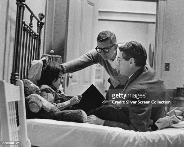 American film director Robert Mulligan talks with actors Mary Badham and Gregory Peck on the set of 'To Kill a Mockingbird' , 1962.