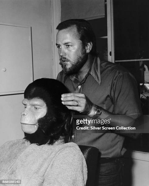 Portrait of American makeup artist Fred Blau works on English-American actor Roddy McDowall to transform him into character backstage for an episode...
