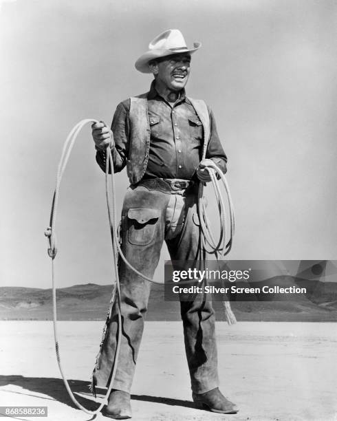 American actor Clark Gable holds a lasso in a scene from the film 'The Misfits' , 1961.