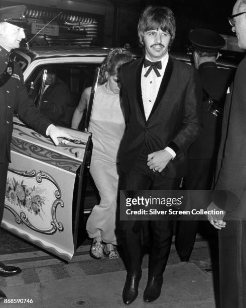 English musician Ringo Starr , of the Beatles, and his wife, Maureen Starkey, step out of a car as they arrive at an unspecified event, late 1960s.