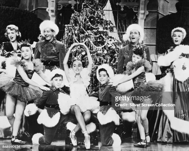 Along with a group of unidentified child actors, actors Rosemary Clooney , Danny Kaye , Bing Crosby , and Vera-Ellen sing in a scene from 'White...