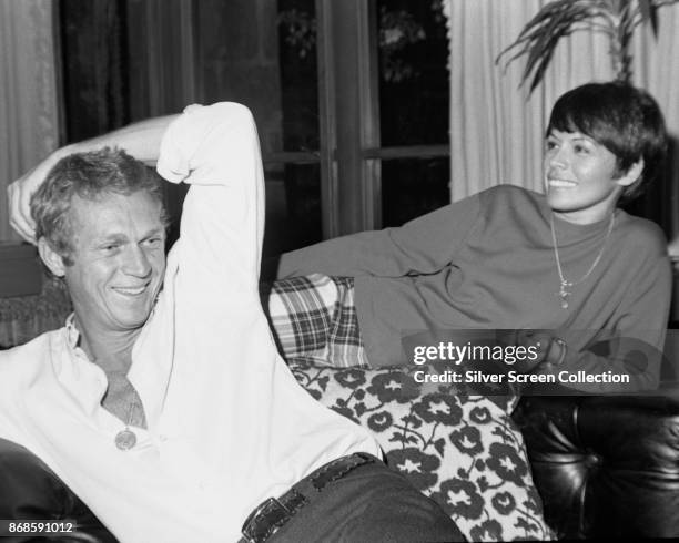 View of married actors Steve McQueen and Neile Adams as they share a laugh at home, Los Angeles, California, 1960s.