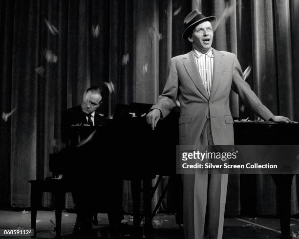 American musician and actor Frank Sinatra , accompanied by Bob Hope on piano, performs during rehearsals for the debut episode of 'The Frank Sinatra...