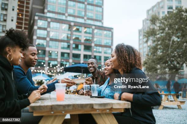 friends enjoying food truck life in new york - picnic table stock pictures, royalty-free photos & images