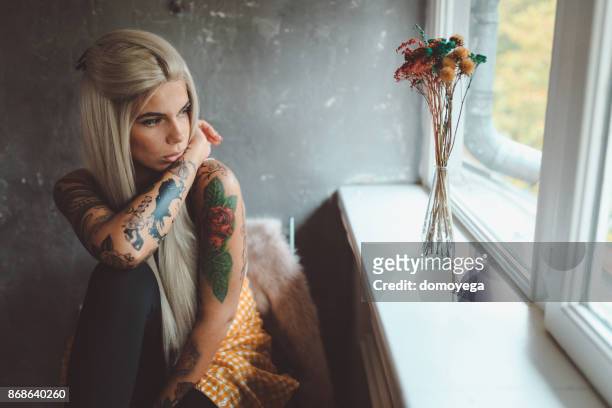 beautiful tattooed woman looking through the window - woman in shower tattoo stock pictures, royalty-free photos & images
