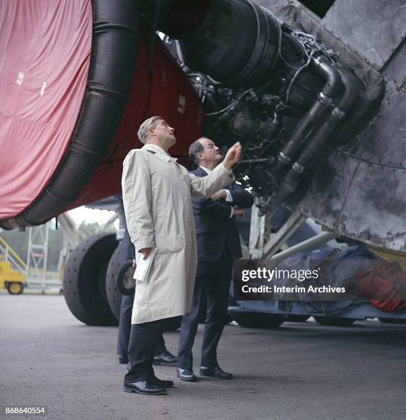 German-born rocket scientist and engineer Werner von Braun points out a rocket's engines to American politician US Vice President Hubert Humphrey...