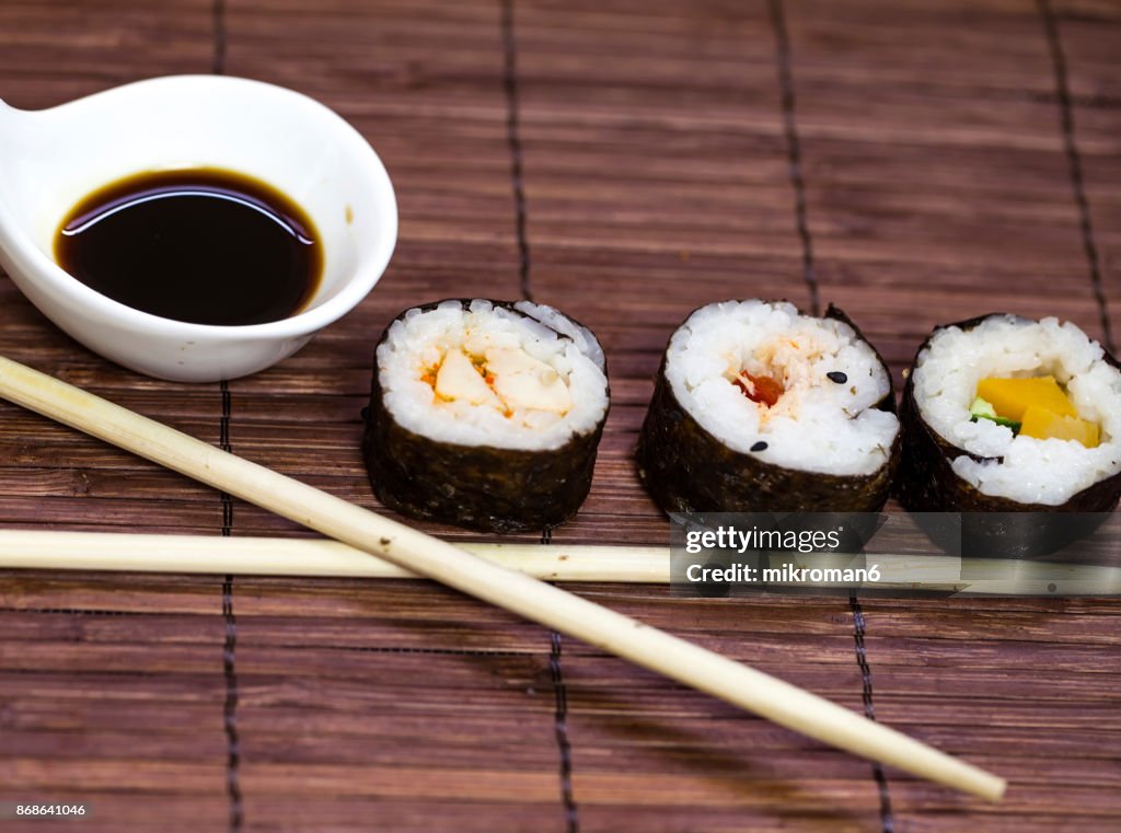 Sushi and chopsticks on a wooden mat