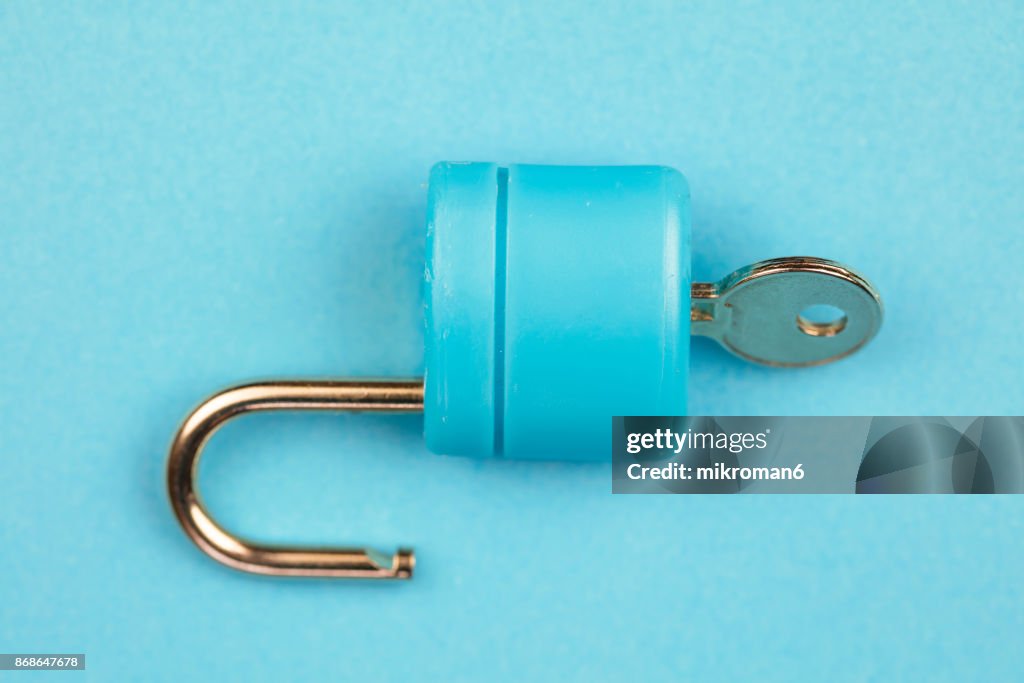 Blue padlock with key on blue background