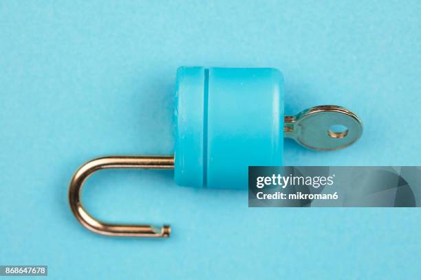 blue padlock with key on blue background - unlocking concept stock pictures, royalty-free photos & images