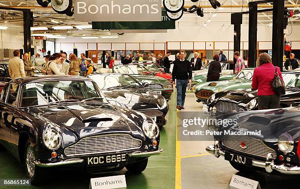 Buyers look at a line of of Aston Martin cars at the Aston Martin Works Service factory during an auction held by Bonham's on May 9, 2009 in Newport...