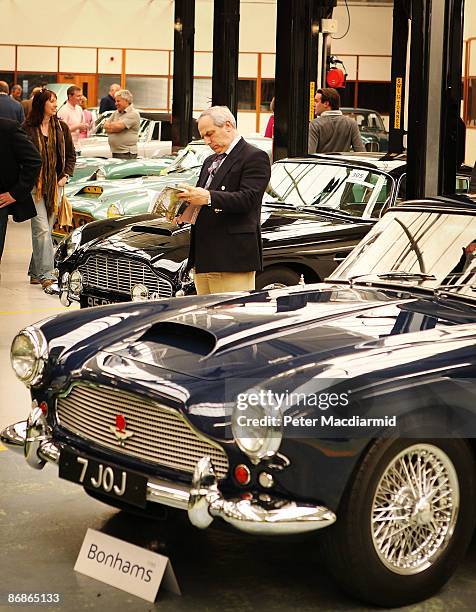 Buyers look at a line of of Aston Martin cars at the Aston Martin Works Service factory during an auction held by Bonham's on May 9, 2009 in Newport...