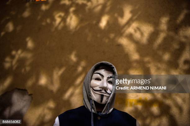 Boy wearing a Guy Fawkes mask poses in the street during Halloween celebrations in Pristina, on October 31, 2017.