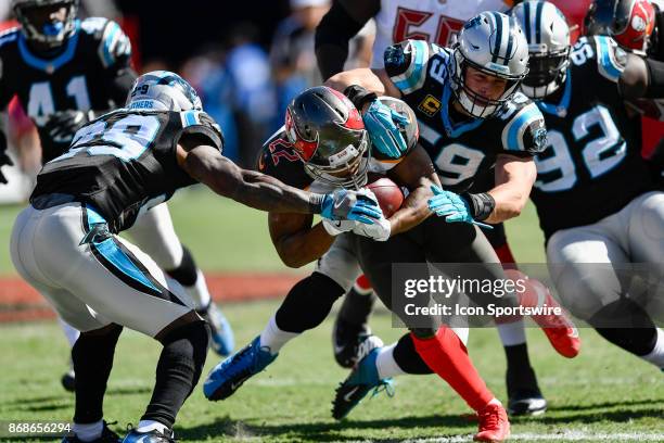 Tampa Bay Buccaneers running back Doug Martin is tackled by Carolina Panthers linebacker Luke Kuechly and Carolina Panthers safety Mike Adams during...