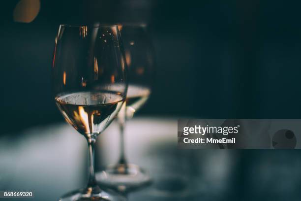 twee glazen witte wijn op een tafel - happy hour stockfoto's en -beelden