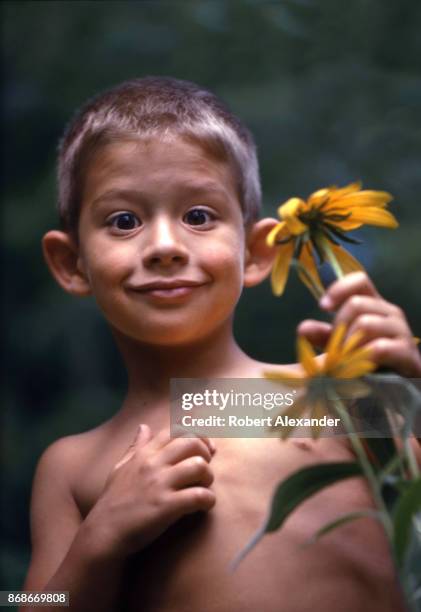 Young boy poses with a sunflower beside his home in Bristol, Tennessee, in 1967.