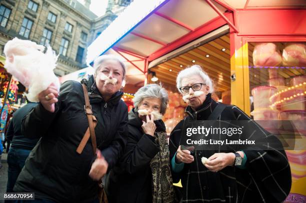 active senior girlfriends enjoying cotton candy at the fair in amsterdam - crazy old people stockfoto's en -beelden