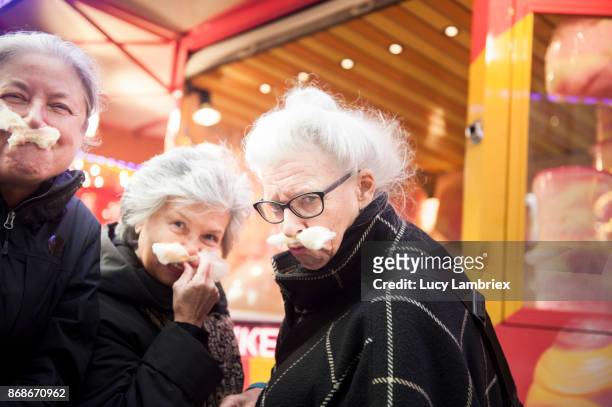 active senior girlfriends enjoying cotton candy at the fair in amsterdam - respektlosigkeit stock-fotos und bilder