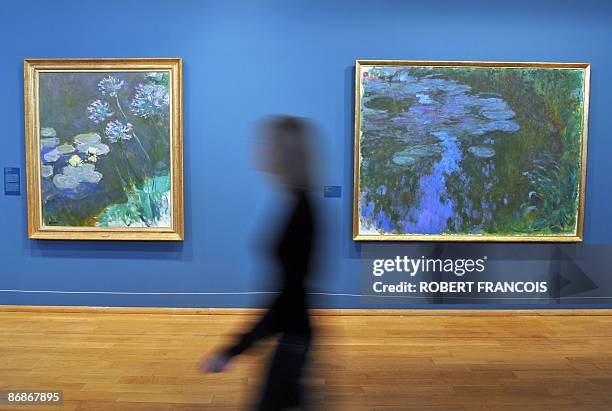 Visitor passes by paintings of "Nympheas" as he visits on May 2009 at the Impressionnists new Museum in Giverny, West of Paris, Normandy, an...
