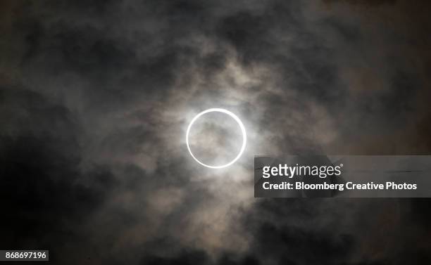 the sun is obscured by the moon during an annular solar eclipse - ringförmige sonnenfinsternis stock-fotos und bilder