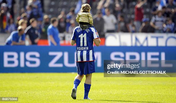 Hertha BSC Berlin's Ukrainian striker Andrej Voronin holds his daughter after the German first division Bundesliga football match Hertha BSC Berlin...