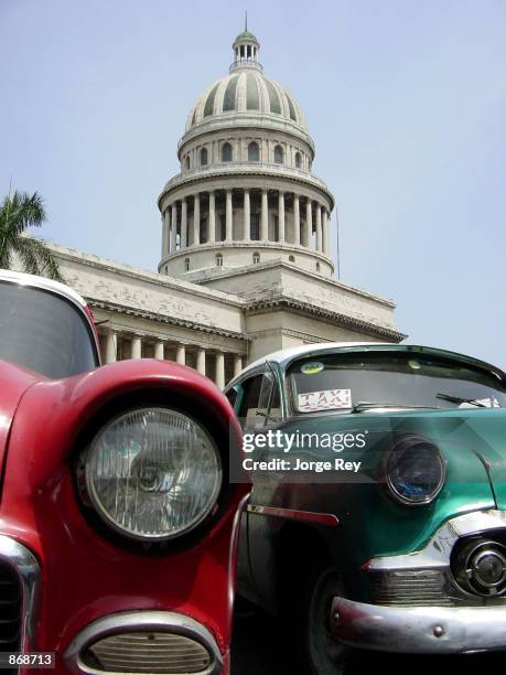 Several earlier model American-made cars wait to be rented June 27, 2002 in Havana, Cuba. Supporters of end to the U.S. Travel ban to Cuba in the...