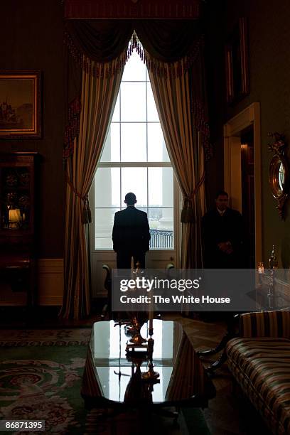 In this handout provide by the White House, U.S. President Barack Obama looks out the Green Room window prior to the "Open for Questions" virtual...