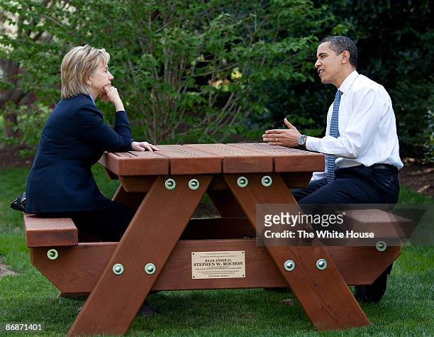 In this handout provide by the White House, U.S. President Barack Obama walks with Secretary of State Hillary Rodham Clinton speak together sitting...
