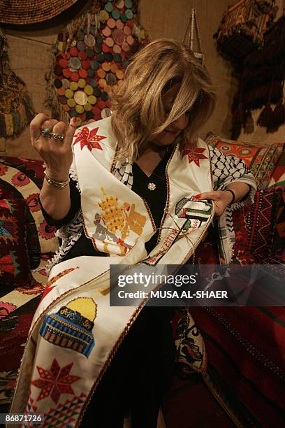 Maha Saca, the head of the Palestinian heritage center, puts the final touches on May 9, 2009 on an embroidered stole with symbols of Palestine and...