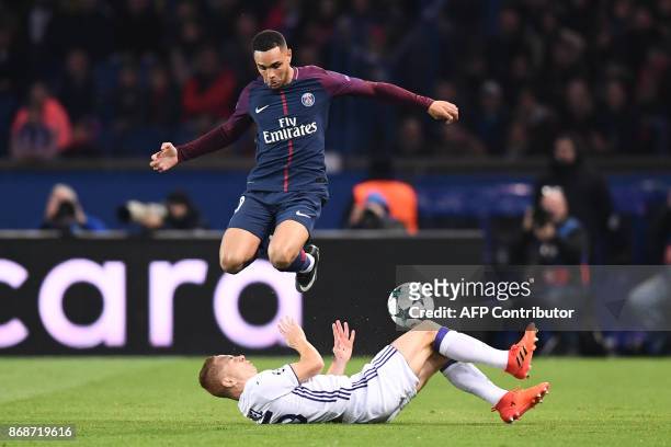 Paris Saint-Germain's French defender Layvin Kurzawa jumps over Anderlecht's French midfielder Adrien Trebel during the UEFA Champions League Group B...