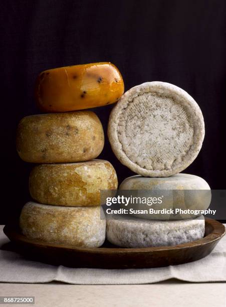 fine artisan made sheep, cow and goat cheese wheels stacked in a still life composition - queso en forma redonda fotografías e imágenes de stock