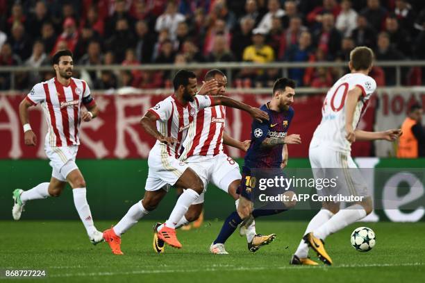 Barcelona's Argentinian forward Lionel Messi vies with Olympiakos players during the UEFA Champions League group D football match between FC...