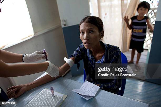 Dawn Mimi Aung gets a blood test as her daughter Ma Nwe Soe looks on at a special clinic for AIDS on April 25, 2009 in Yangon, Myanmar . The...