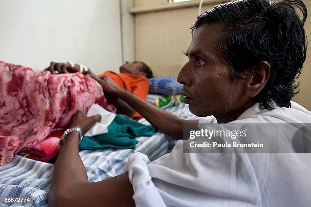 Rohingya man sits along his wife suffering from AIDS at a special clinic for AIDS on April 29, 2009 in Yangon, Myanmar . The situation for many...